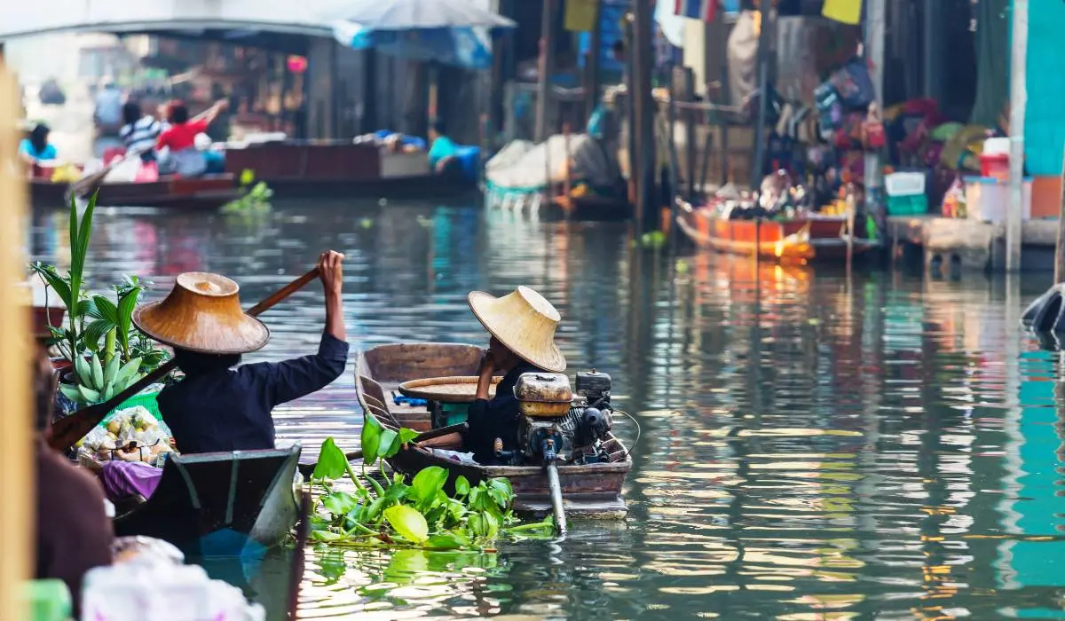 A lively scene at the Damnoen Saduak floating market in Thailand, where vendors sell a variety of goods from boats on the canal